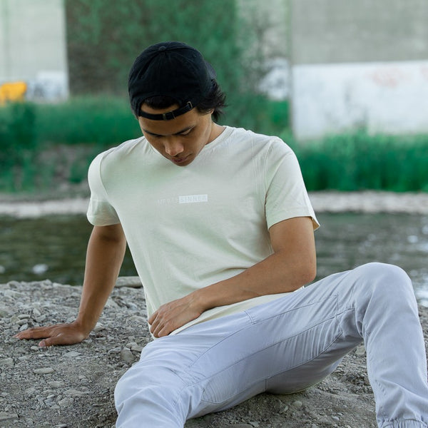 man modeling beige t-shirt with  white text, "MT913 Sinner."