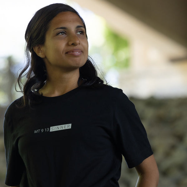 woman modeling black t-shirt with  white text, "MT913 Sinner."